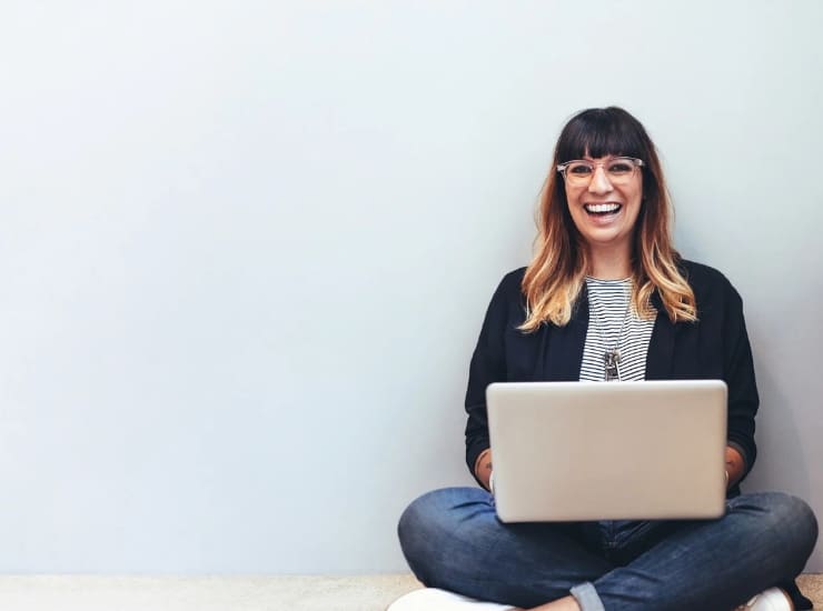 Donna seduta al computer che sorride